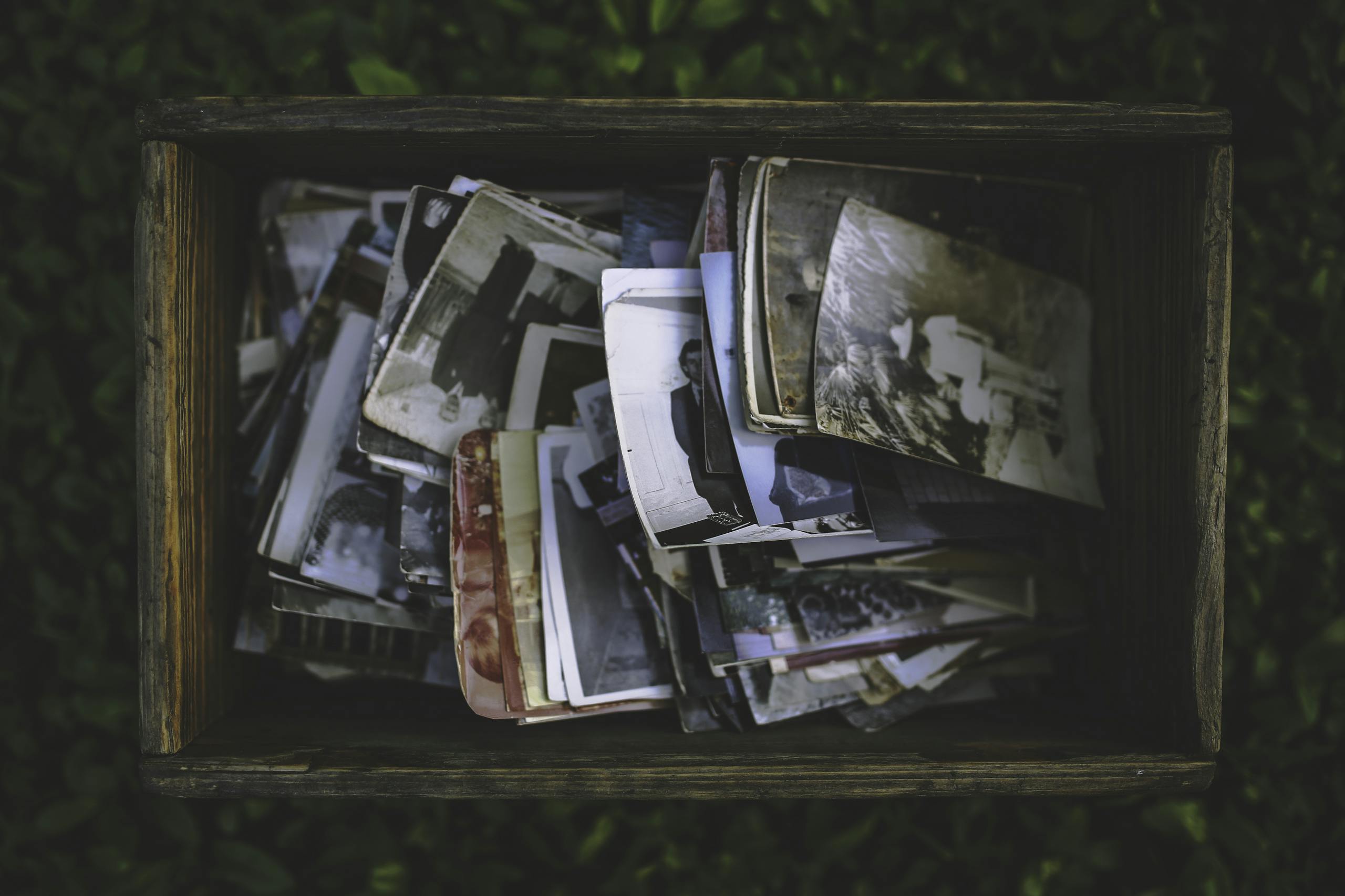 A nostalgic collection of vintage photos in an old wooden box.